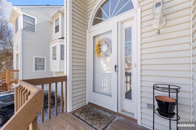 view of exterior entry featuring a wooden deck