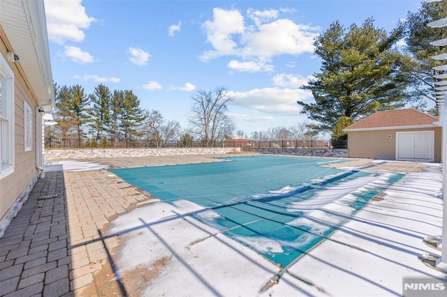 view of pool featuring a patio area, a fenced backyard, a fenced in pool, and an outdoor structure