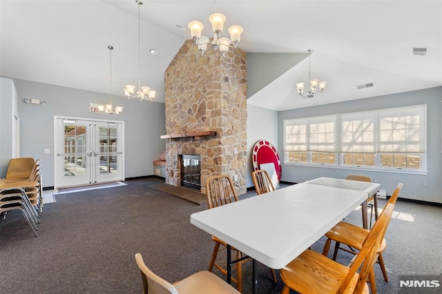 dining area with high vaulted ceiling, visible vents, a fireplace, and a chandelier