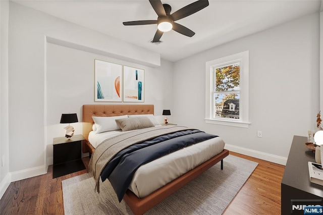 bedroom with ceiling fan, baseboards, and wood finished floors