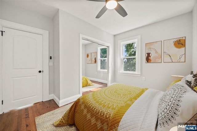 bedroom with ceiling fan, baseboards, and wood finished floors