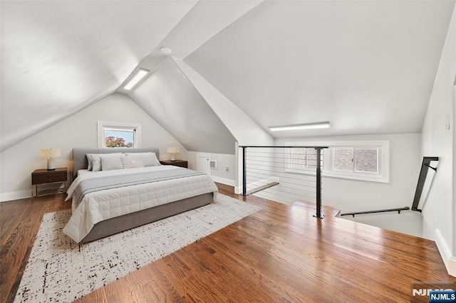 bedroom featuring vaulted ceiling, baseboards, and wood finished floors