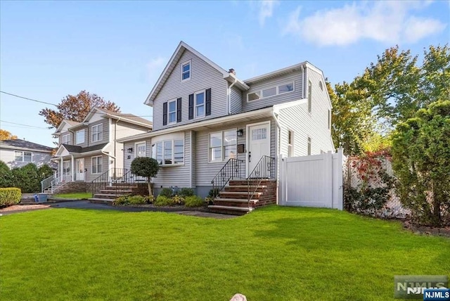 view of front facade featuring a front yard and fence