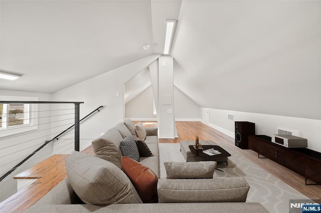 living room with lofted ceiling, visible vents, and wood finished floors