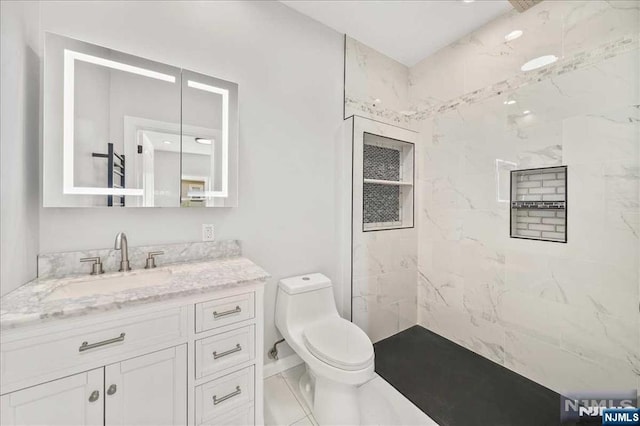 full bath with toilet, a marble finish shower, and vanity