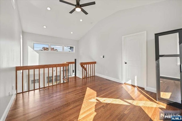 empty room featuring recessed lighting, a ceiling fan, vaulted ceiling, wood finished floors, and baseboards