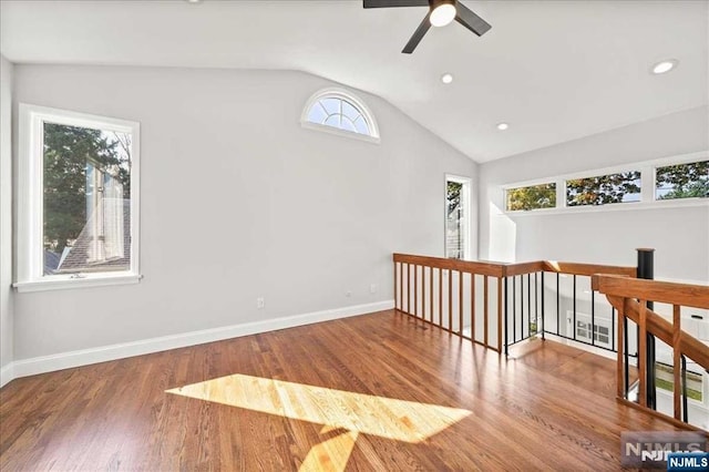 spare room with lofted ceiling, recessed lighting, a ceiling fan, wood finished floors, and baseboards