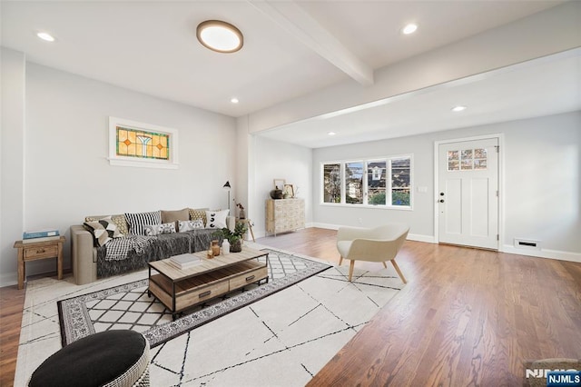 living room featuring light wood-style flooring, baseboards, beamed ceiling, and recessed lighting