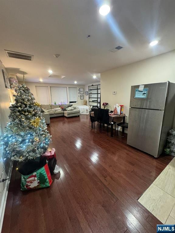 living room with dark wood-type flooring, visible vents, and recessed lighting