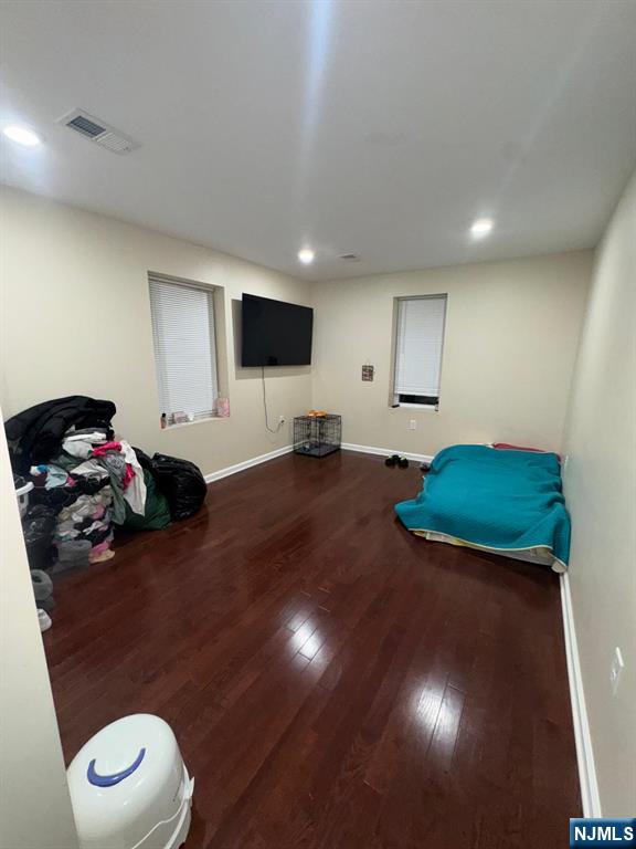 bedroom with recessed lighting, wood finished floors, visible vents, and baseboards