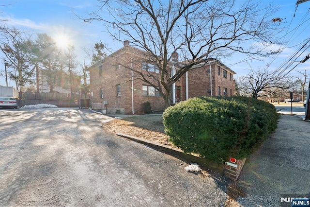 view of side of home featuring brick siding and a chimney