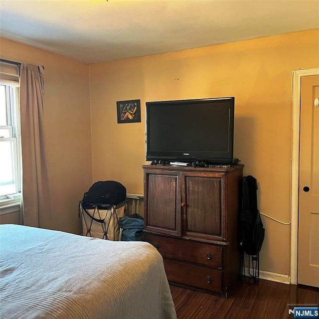 bedroom featuring dark wood-style floors and baseboards