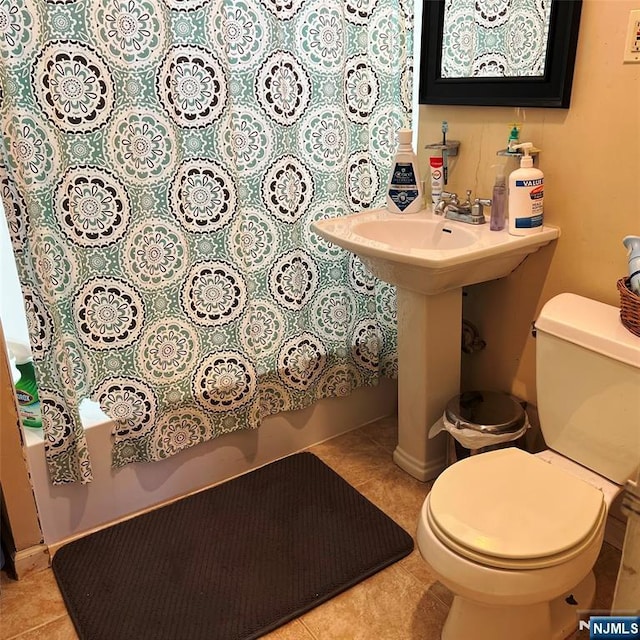 bathroom with toilet, baseboards, and tile patterned floors