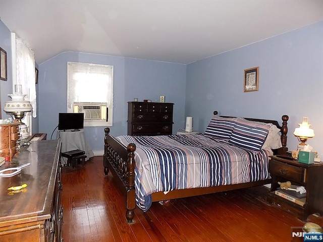 bedroom featuring dark wood-style floors, vaulted ceiling, and cooling unit