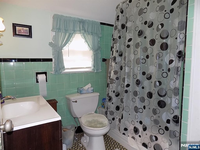 full bathroom featuring toilet, curtained shower, tile walls, and vanity