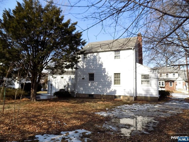 snow covered property featuring a chimney