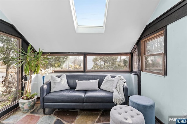 sunroom featuring lofted ceiling with skylight