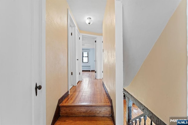 corridor with radiator heating unit and wood-type flooring