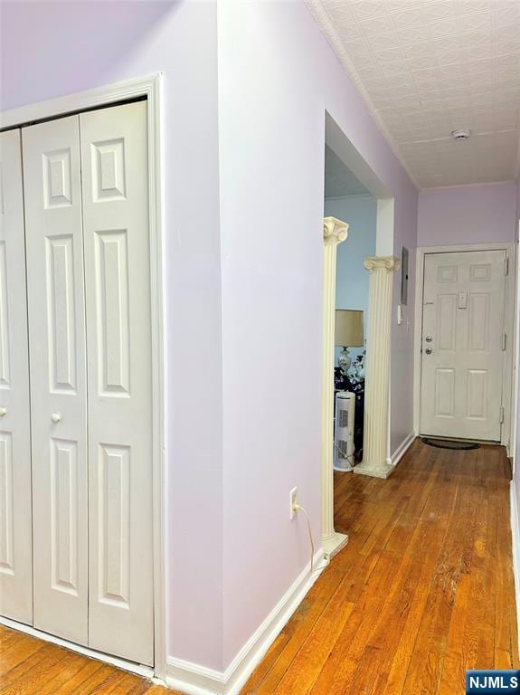 hall with wood-type flooring and baseboards