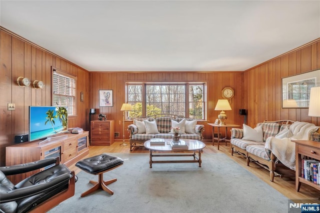 living area featuring light wood-style flooring and crown molding