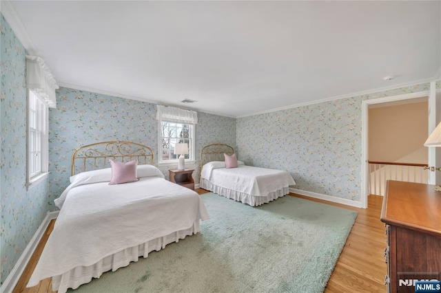 bedroom featuring wallpapered walls, light wood-style flooring, ornamental molding, and baseboards