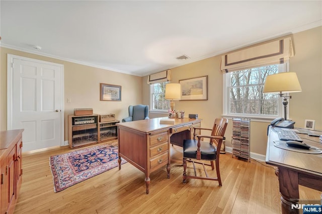 office featuring ornamental molding, light wood-type flooring, visible vents, and baseboards