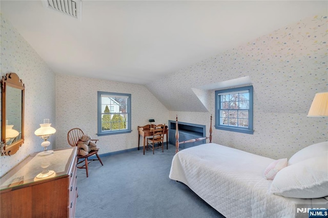 bedroom with lofted ceiling, wallpapered walls, visible vents, and dark carpet