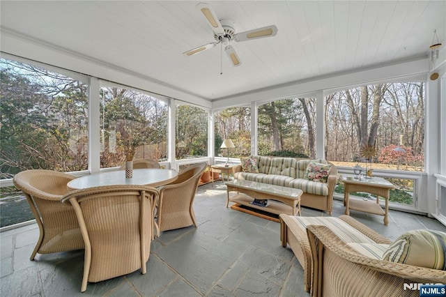 sunroom featuring wooden ceiling and a ceiling fan