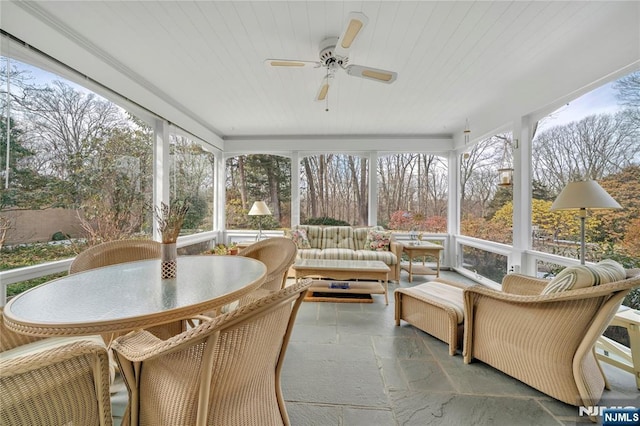 sunroom featuring a healthy amount of sunlight, wooden ceiling, and ceiling fan