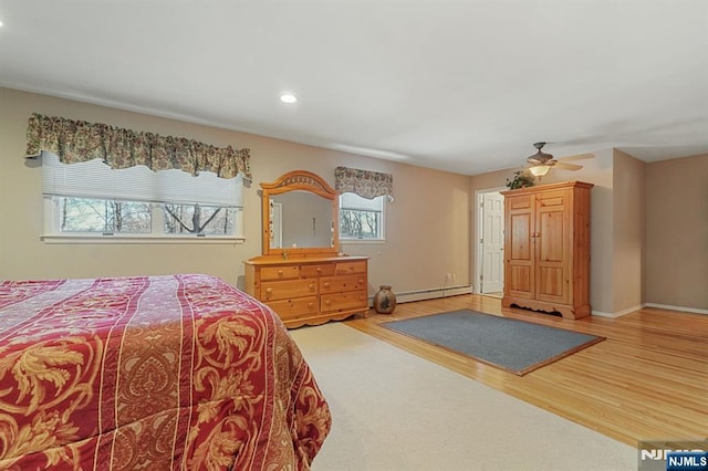 bedroom with baseboards, baseboard heating, wood finished floors, and recessed lighting