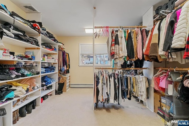 spacious closet with carpet floors, a baseboard radiator, and visible vents