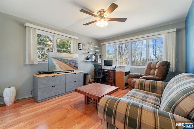 interior space featuring light wood finished floors, a ceiling fan, and baseboards