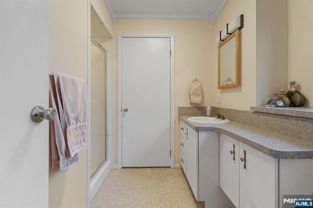 full bath featuring a stall shower, tile patterned floors, vanity, and crown molding