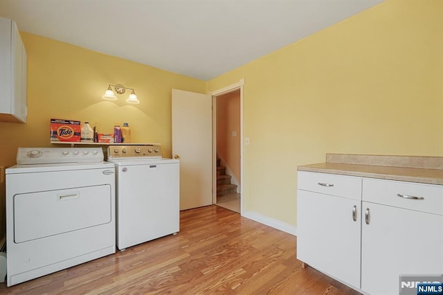 clothes washing area with light wood-style floors, baseboards, cabinet space, and independent washer and dryer