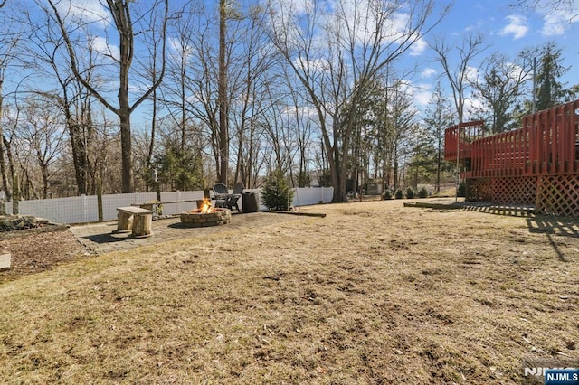 view of yard featuring an outdoor fire pit, fence, and a deck