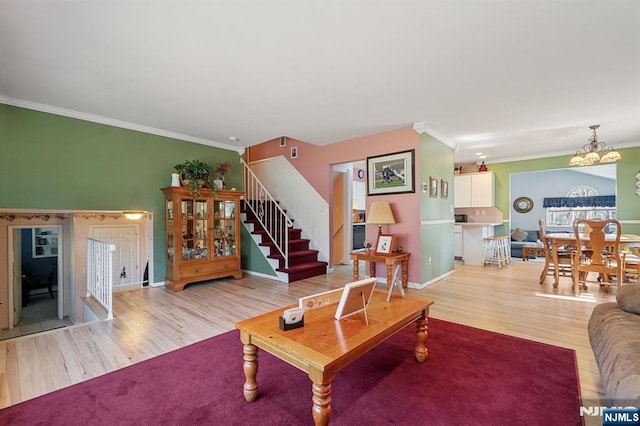 living area featuring ornamental molding, stairway, wood finished floors, and baseboards