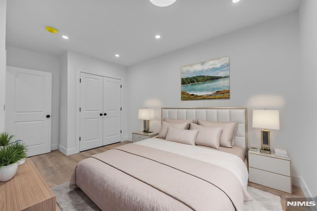 bedroom featuring a closet, baseboards, wood finished floors, and recessed lighting