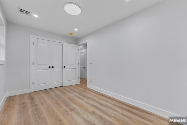 unfurnished bedroom with baseboards, visible vents, light wood-type flooring, a closet, and recessed lighting