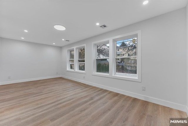 empty room with light wood-type flooring and baseboards