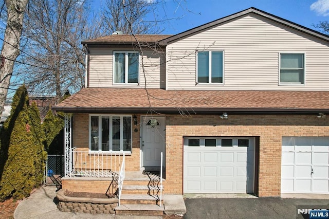 view of front of house with aphalt driveway, roof with shingles, and brick siding