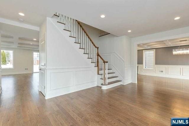 interior space with stairs, a decorative wall, dark wood-type flooring, and recessed lighting