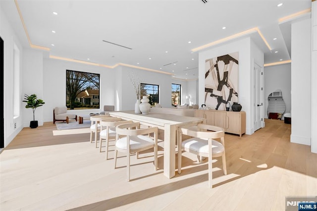 dining space featuring recessed lighting, baseboards, crown molding, and light wood-style floors