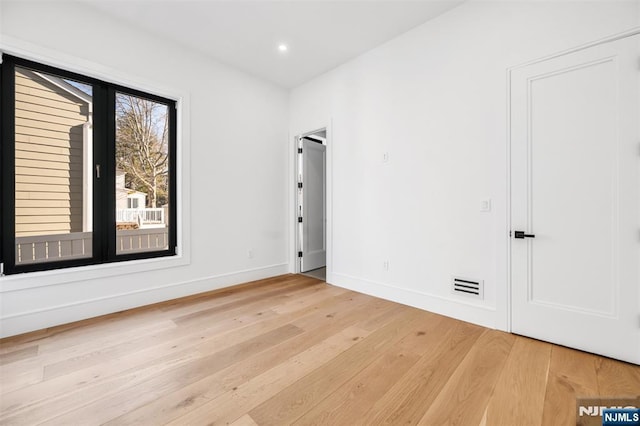 unfurnished room with recessed lighting, light wood-style floors, visible vents, and baseboards