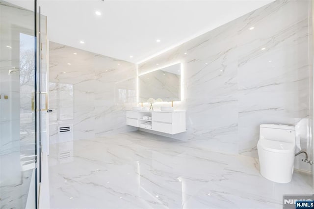 full bathroom with marble finish floor, toilet, stone wall, and vanity