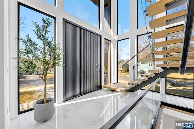 interior space featuring marble finish floor and a towering ceiling