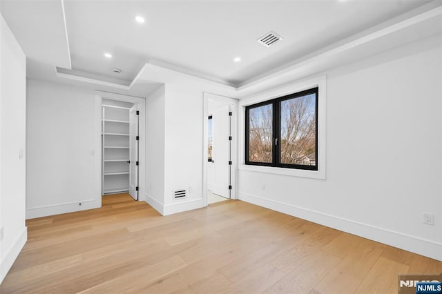 unfurnished bedroom with visible vents, baseboards, and light wood-style flooring