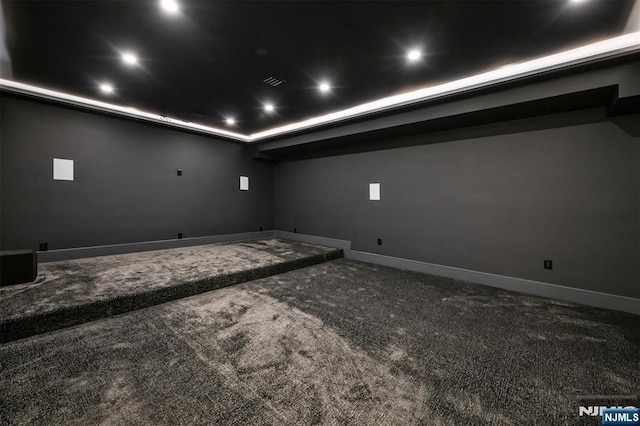 carpeted home theater room featuring a raised ceiling, recessed lighting, and baseboards