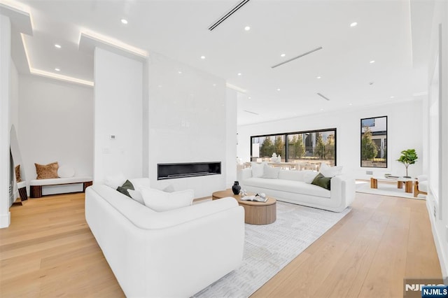 living room with recessed lighting, light wood-style floors, and a fireplace