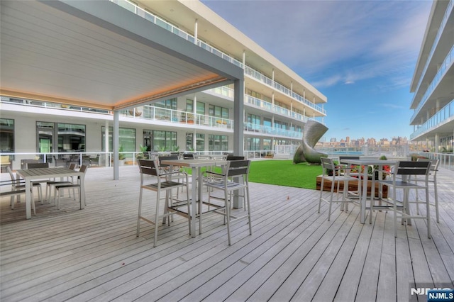 wooden terrace with a view of city and outdoor dining area