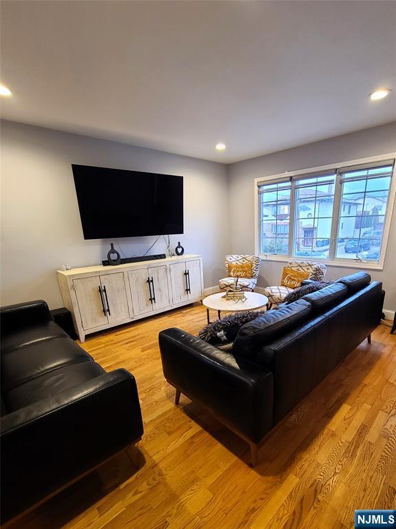 living area featuring light wood finished floors, baseboards, and recessed lighting